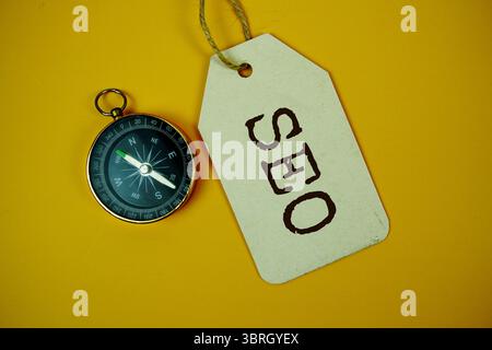 SEO Suchmaschinenoptimierung Text auf Preisschild mit Kompass auf Korkbrett Hintergrund Stockfoto