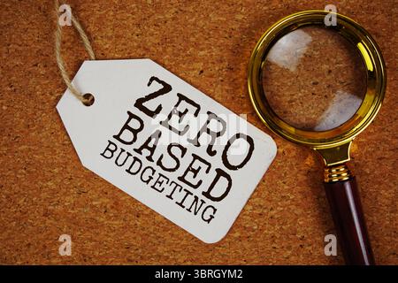 Nullbasierter Budgettext auf Preisschild mit Lupe auf Korkbrett Hintergrund Stockfoto