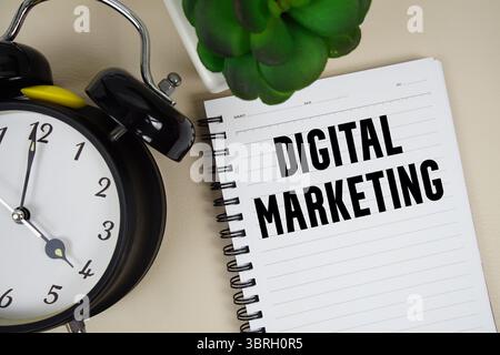 Text für digitales Marketing auf Notizblock mit Wecker geschrieben Stockfoto