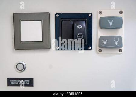 Nahaufnahme der Bedienknöpfe für Toilettenspülung und Duschwasseranlage auf einer Yacht. Praktische Details, Wasserversorgung und Alltag an Bord. Stockfoto