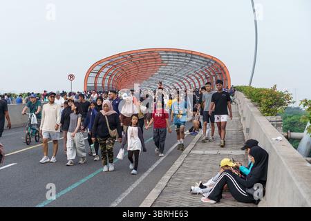 Bekasi, Indonesien, 13. Juli 2025: Eine große Menschenmenge, die während eines autofreien Wochenendtags auf einer modernen Fußgängerbrücke spaziert und trainiert Stockfoto