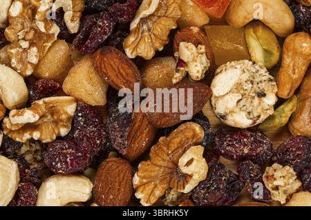 Blick von oben auf einen Haufen getrockneter bunter Frühstücksmischung Nüsse und Früchte, Hintergrund, Nahaufnahme, horizontal Stockfoto