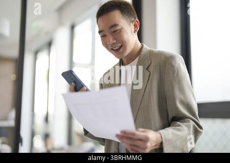 Junger Geschäftsmann mit Smartphone, der mobile Geräte in der Hand hat. Mobiltelefontechnologie E-Commerce-Smartphone für Unternehmen Stockfoto