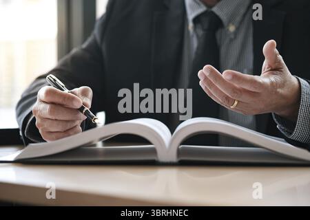 Rechtsberater präsentiert auf dem Client einen unterzeichneten Vertrag mit Hammer und rechtlichen Gesetz. Justiz und Rechtsanwalt Konzept Stockfoto