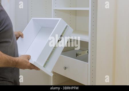 Installation der Arbeiter stellt die Schublade im Schrank Schrank Möbel im neuen Haus Stockfoto