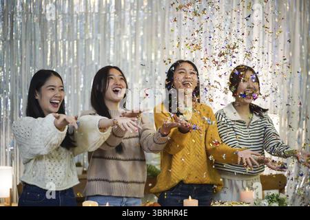 Fröhliche Freunde, die zu Hause Geburtstagsfeier genießen. Asiatische Freunde feiern Weihnachten oder Silvesterparty Stockfoto