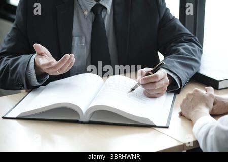 Rechtsberater präsentiert auf dem Client einen unterzeichneten Vertrag mit Hammer und rechtlichen Gesetz. Justiz und Rechtsanwalt Konzept Stockfoto