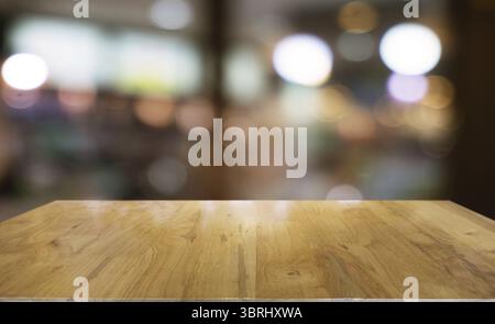 Leerer Holztisch vor abstraktem, verschwommenem Hintergrund des Cafés. Kann für die Anzeige von Produktmodellen verwendet werden Stockfoto