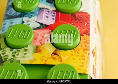 Tyumen, Russland-8. Juli 2025: Ein lebhafter, grüner Baustein Lego wird vor einer hellen und farbenfrohen Kulisse sichtbar. Stockfoto