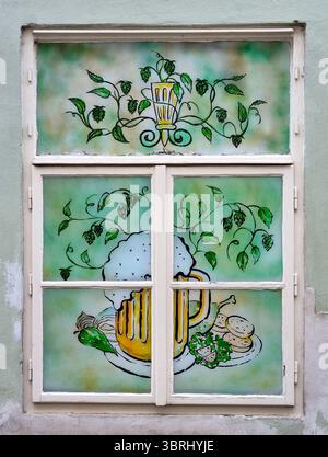 Gemälde auf Fensterglas mit Buntglasoptik, die einen Becher mit tschechischem Bier und traditionellen Snacks in Prag, Tschechische Republik, darstellt Stockfoto