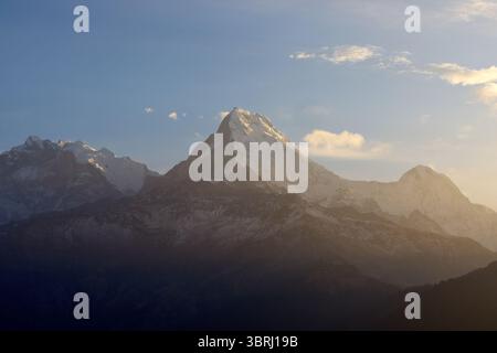 Der majestätische Gipfel von South Annapurna erhebt sich gegen den glühenden Himmel und zeigt die Schönheit des Himalaya bei einem ruhigen Sonnenaufgang am Poon Hill, Nepal. Stockfoto