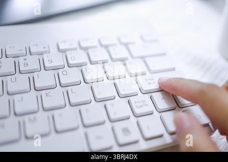 Hände einer Geschäftsfrau Zeigefinger drücken die Eingabetaste auf der Computertastatur Stockfoto