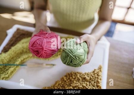 Stanznadel. Asiatische Frau, die handgemachtes Hobby-Stricken in der Atelierwerkstatt herstellt. Designer-Arbeitsplatz Handgefertigtes Bastelprojekt DIY Stickkonzept Stockfoto