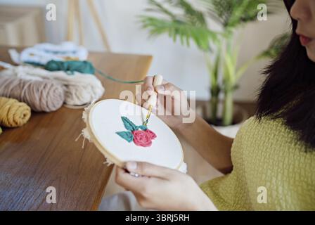 Stanznadel. Asiatische Frau, die handgemachtes Hobby-Stricken in der Atelierwerkstatt herstellt. Designer-Arbeitsplatz Handgefertigtes Bastelprojekt DIY Stickkonzept Stockfoto