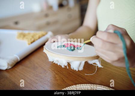 Stanznadel. Asiatische Frau, die handgemachtes Hobby-Stricken in der Atelierwerkstatt herstellt. Designer-Arbeitsplatz Handgefertigtes Bastelprojekt DIY Stickkonzept Stockfoto