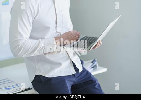 Junger Geschäftsmann, der im Büro arbeitet. Geschäftsmann mit Computer Laptop Business Management Konzept Stockfoto