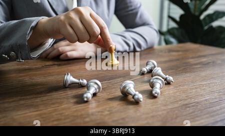 Schachführung Siegeskonzept mit Goldsieger Stand Alone mit gefallenen silbernen Schachfiguren König gewinnt das Spiel Entscheidung und Leistung Ziel Konzept Stockfoto