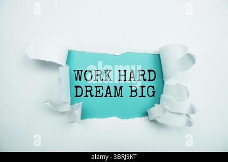 Work Hard Dream große Botschaft auf blauem Papier mit zerrissenem Papierhintergrund Stockfoto