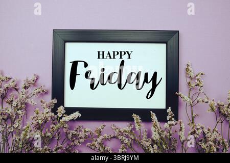 Happy Friday Text mit Blumenstrauß Dekoration auf lila Hintergrund Stockfoto