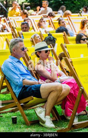 London, Großbritannien. Juli 2025. Sonniges Wetter bedeutet Strohhüte und Shorts zum Entspannen auf den Liegestühlen, um das Herrenfinale zu beobachten. Marylebones kostenloses Festival kehrt mit einer Woche Wimbledon, Street Food und Familienspaß im Portman Square Garden vom 8. Bis 13. Juli zurück. Es bietet eine Gästeküche mit Pop-ups von lokalen Favoriten, Tennis auf der Großleinwand, Kunstworkshops, eine Bar am Home House und liegt in einem der schönsten Grünflächen Londons, die selten für die Öffentlichkeit zugänglich sind. Guy Bell/Alamy Live News Stockfoto