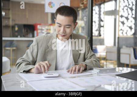 Zuversichtlicher asiatischer Geschäftsmann Wirtschaftsprüfer oder interne Mitarbeiter des Ertragsdienstes prüfen Jahresabschlüsse Unternehmen Audit Accounting Tax Stockfoto