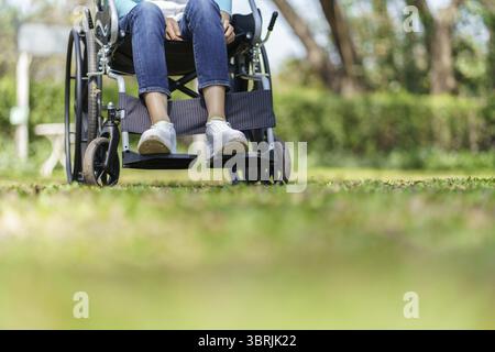 Junge asiatische Frau im Rollstuhl mit positivem Denken Stockfoto