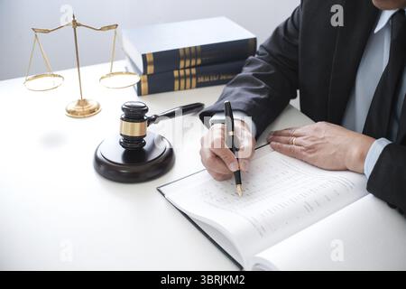 Rechtsberater präsentiert auf dem Client einen unterzeichneten Vertrag mit Hammer und rechtlichen Gesetz. Justiz und Rechtsanwalt Konzept Stockfoto