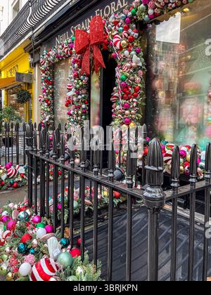 London, Vereinigtes Königreich - 28. Dezember 2023: Der Neill Strain Floral Store in London ist wunderschön für den Winter dekoriert, mit farbenfrohen Ornamenten und Stockfoto