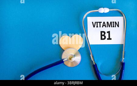 Vitamin B1-Symbol. Concept Words Vitamin B1 auf schöner weißer Karte. Holzherz und Stethoskop. Wunderschöner blauer Hintergrund. Medizinisches gesundes lifestyl Stockfoto