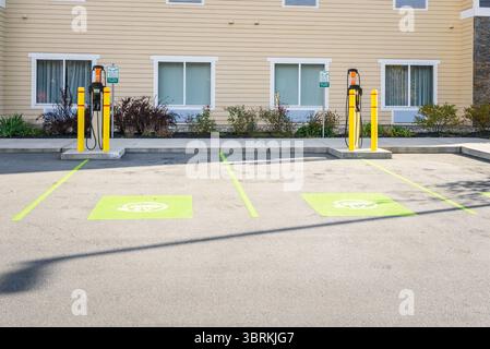 Leere Ladestation für Elektroautos hinter einem Gebäude an einem sonnigen Tag Stockfoto