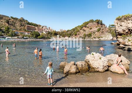 Taormina, Sizilien, Italien - 29. September 2024: Die Menschen schwimmen und genießen das klare Wasser am Strand Isola Bella in Taormina. Stockfoto