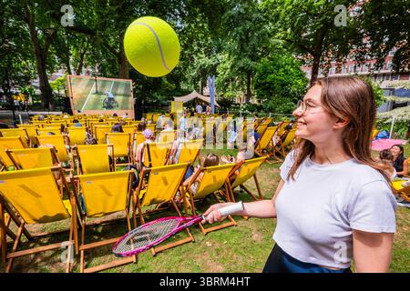 London, Großbritannien. Juli 2025. Wimbledon Vibes: Heißes, sonniges Wetter, Spaß mit riesigen Tennisbällen und das Finalspiel auf dem großen Bildschirm - Marylebones kostenloses Festival kehrt mit einer Woche Wimbledon, Streetfood, Wellness und Familienspaß im Portman Square Garden vom 8. Bis 13. Juli zurück. Es bietet eine Gästeküche mit Pop-ups von lokalen Favoriten, Tennis auf der Großleinwand, Kunstworkshops, eine Bar am Home House und liegt in einem der schönsten Grünflächen Londons, die selten für die Öffentlichkeit zugänglich sind. Guy Bell/Alamy Live News Stockfoto
