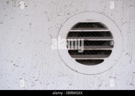 Schmutzige und staubige Lüftungsblende an der Wand des Wohngebäudes. Belüftung und Temperaturregelung. Instandhaltung des Haushalts, Reinigungsdienste Stockfoto