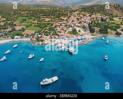 Atemberaubende Aussicht auf das türkische Dorf Ildir aus der Vogelperspektive mit kristallklarem türkisfarbenem Wasser, zahlreichen verankerten Booten und üppigem Grün Stockfoto