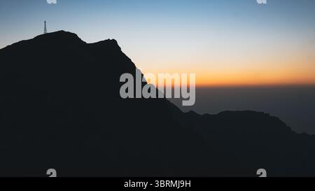 Filmische Silhouette des Berggipfels bei Sonnenuntergang Stockfoto