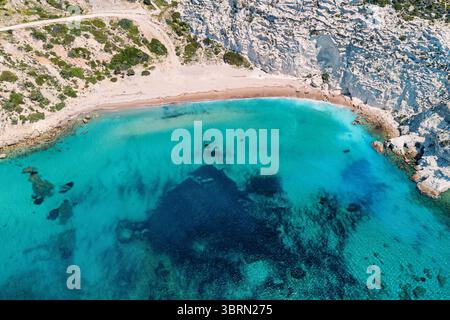 Atemberaubende Luftperspektive, die das faszinierende türkisfarbene Wasser mit einem malerischen weißen Sandstrand einfängt und einen atemberaubenden Küstenpano schafft Stockfoto
