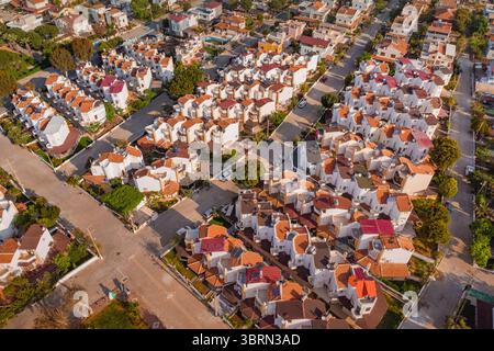 Blick aus der Vogelperspektive auf ein Wohngebiet mit Häusern mit orangefarbenen Dächern, die die städtische Landschaft einer Küstenstadt darstellen Stockfoto