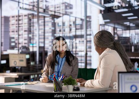 Kompetente Geschäftsfrauen diskutieren strategische Planung in einem Unternehmensbüro und demonstrieren Teamarbeit und Gleichstellung der Geschlechter in der Geschäftsbranche. Ehrgeizige Frauen arbeiten an ihrer Erfolgsgeschichte zusammen. Stockfoto