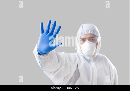 Mann im Schutzanzug macht Stoppschild mit Hand Stockfoto