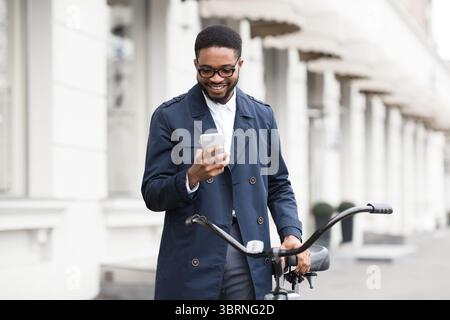 Art und Weise zu arbeiten. Man sms auf Telefon, stehend mit dem Fahrrad Stockfoto