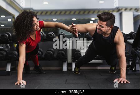 Ein Paar gibt High-5, während er Liegestütze macht Stockfoto
