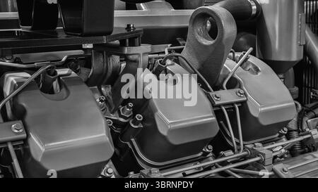 Schwarzer Motor mit drei Zylindern. Der Motor befindet sich in einem Werk Stockfoto