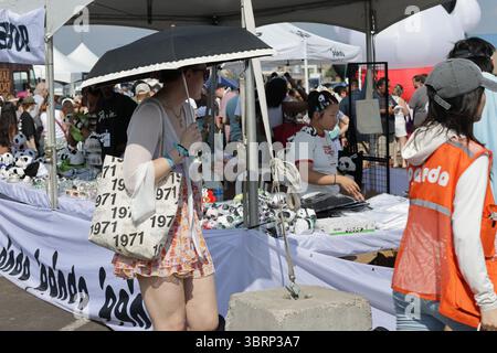 Bloomington, MN, USA. Juli 2025. Junge Frau, die sich vor der Sommerhitze unter einem Schirm bei den ausverkauften Panda fest Twin Cities schützt, die asiatische Kultur feiern. Das Panda fest ist eines der größten asiatischen Open-Air-Food-Festivals in den USA und bringt Hunderte authentischer asiatischer Speisen, Street Food und Kunstverkäufer auf den nördlichen Parkplatz der Mall of America. Quelle: Mariko Okada/Alamy Live News Stockfoto