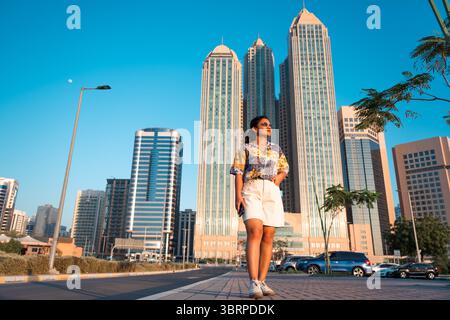 Junge Frau, die in der Stadt spaziert, kluger Tourist, der die Stadt Abu Dhabi erkundet, citywalk Stockfoto