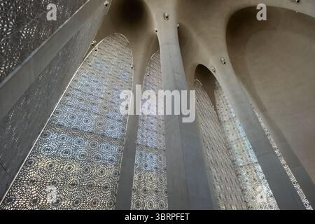 Komplexe architektonische Säulen mit kunstvollen Gitterfenstern unter einer Bogendecke, die eine Kombination aus geometrischen Mustern und natürlichem Licht zeigen Stockfoto