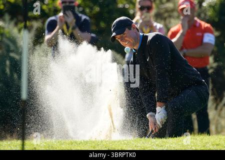 Rory McIlroy plätschert aus der Bunkerfalle, während der Ball in der Luft in Richtung Grün liegt ​The. Am ersten Tag fand die BMW PGA Championship 2019, die 65. Ausgabe dieser prestigeträchtigen European Tour, vom 19. Bis 22. September 2019 auf dem West Course des Wentworth Clubs in Virginia Water, Surrey, England, statt. Dieses Turnier markierte eine bedeutende Änderung im Golfkalender, da es zum ersten Mal auf September verschoben wurde und damit dem überarbeiteten globalen Golfkalender entsprach. Stockfoto