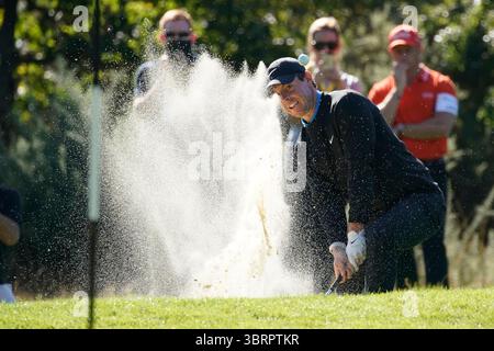 Rory McIlroy plätschert aus der Bunkerfalle, während der Ball in der Luft in Richtung Grün liegt ​The. Am ersten Tag fand die BMW PGA Championship 2019, die 65. Ausgabe dieser prestigeträchtigen European Tour, vom 19. Bis 22. September 2019 auf dem West Course des Wentworth Clubs in Virginia Water, Surrey, England, statt. Dieses Turnier markierte eine bedeutende Änderung im Golfkalender, da es zum ersten Mal auf September verschoben wurde und damit dem überarbeiteten globalen Golfkalender entsprach. Stockfoto
