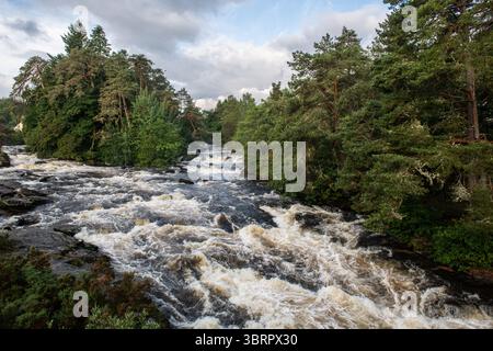 Rauschende Wildwasserstromschnellen der Falls of Dochart in der Stadt Killin, Perthshire, im zentralen schottischen Hochland. Stockfoto