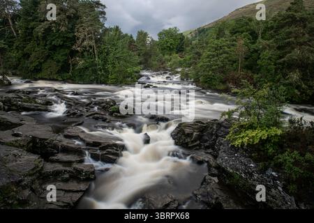 Rauschende Wildwasserstromschnellen der Falls of Dochart in der Stadt Killin, Perthshire, im zentralen schottischen Hochland. Stockfoto