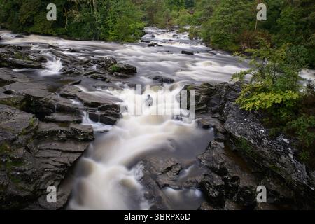 Rauschende Wildwasserstromschnellen der Falls of Dochart in der Stadt Killin, Perthshire, im zentralen schottischen Hochland. Stockfoto
